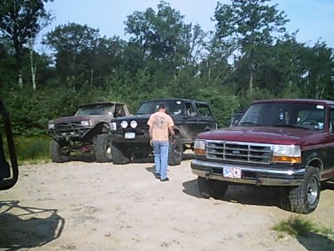 1988 Ford Bronco - Maroon Ford F-150 front end visible with two other SUVs behind it.