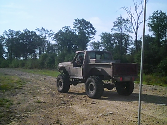 Modified pickup truck with large tires on a dirt road