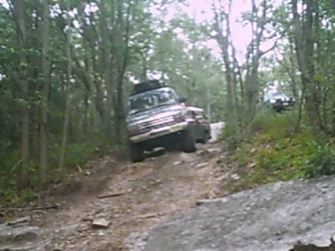 1988 Ford Bronco - A 1988 Ford Bronco navigates a rocky, wooded trail during an off-road excursion.