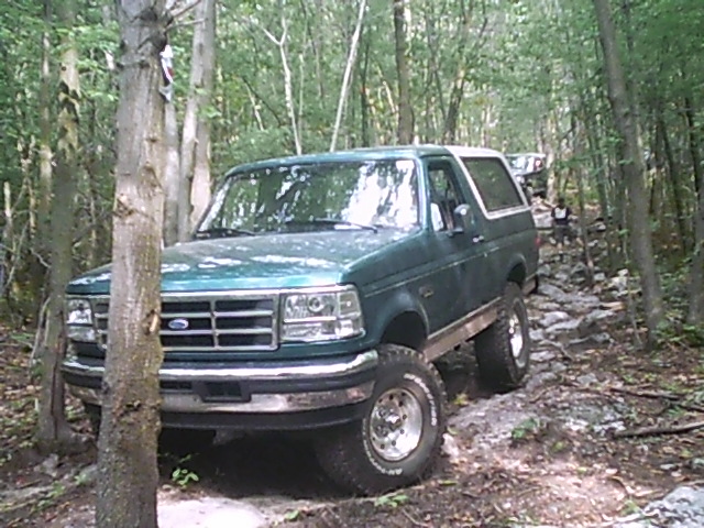Green Ford Bronco on a rocky trail