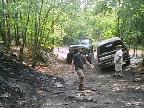1988 Ford Bronco - Two SUVs navigate a challenging dirt trail during an off-road excursion.