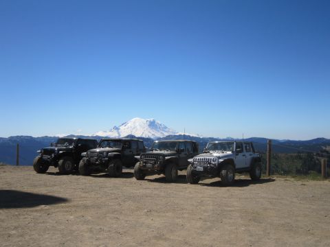 2008 Jeep Wrangler - A group of Jeeps are parked on a scenic overlook with a large mountain in the distance.