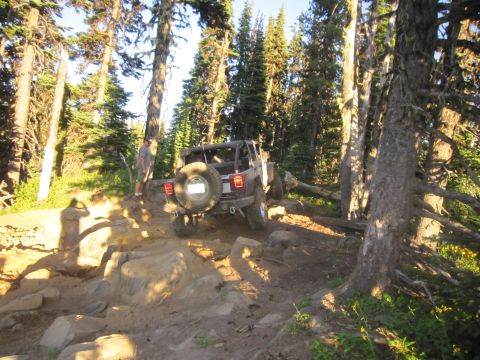 2008 Jeep Wrangler - Jeep Wrangler tackling a challenging rocky trail in a wooded area.