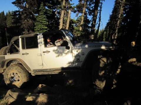 2008 Jeep Wrangler - A white Jeep Wrangler Rubicon navigates a rocky trail through a forest.