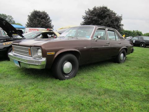1991 Ford LTD Crown Victoria - Brown four-door sedan with chrome grille and hubcaps parked on grass among other vehicles at an outdoor car show.