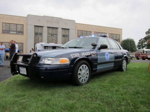 1991 Ford LTD Crown Victoria - dark blue State Police Ford Crown Victoria numbered 1257 with push bumper and light bar sits on grass at a vehicle show.