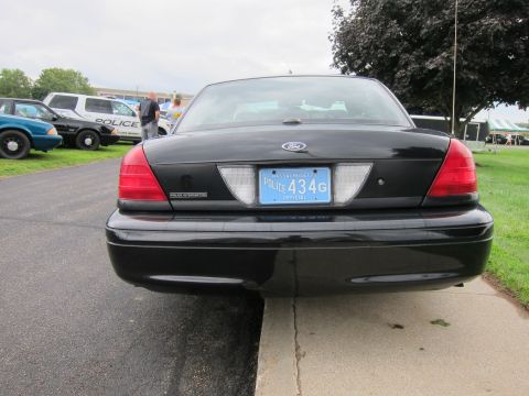 1991 Ford LTD Crown Victoria - Rear view of a black Ford Crown Victoria police interceptor with a Massachusetts official POLICE 434G plate on grass.