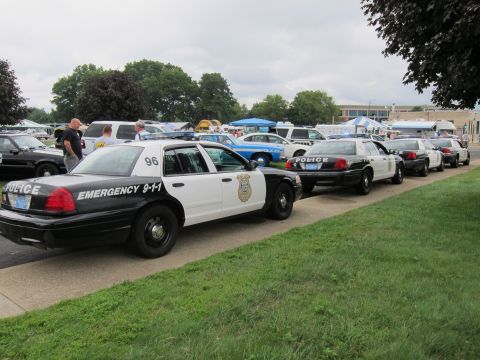 1991 Ford LTD Crown Victoria - black-and-white police Crown Victoria numbered 96 marked Emergency 9-1-1 leads a long row of patrol cars at a show.