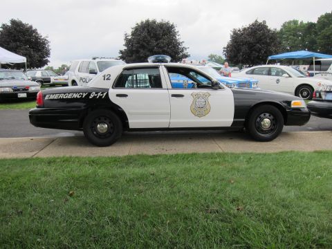 1991 Ford LTD Crown Victoria - black-and-white police Ford Crown Victoria numbered 12 marked Emergency 9-1-1 is parked in profile on grass at a show.
