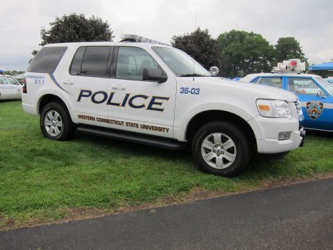 1991 Ford LTD Crown Victoria - white Ford Explorer SUV marked Police, Western Connecticut State University, numbered 36-03, parked on grass at a show.