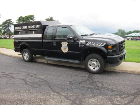 1991 Ford LTD Crown Victoria - Front three-quarter view of a black Ford F-250 4x4 pickup marked Police Crime Scene Unit, Springfield, with a covered bed.