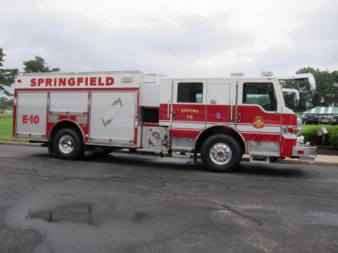 1991 Ford LTD Crown Victoria - Profile view of a red-and-silver Springfield Engine 10 fire engine parked at the curb on a paved lot.