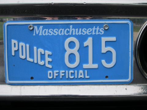 1991 Ford LTD Crown Victoria - Close-up of a blue Massachusetts POLICE OFFICIAL license plate reading 815 mounted on a chrome bumper.