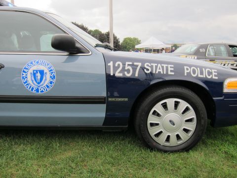 1991 Ford LTD Crown Victoria - Close-up of a two-tone blue Massachusetts State Police Ford sedan showing the state seal and '1257 STATE POLICE' door lettering.