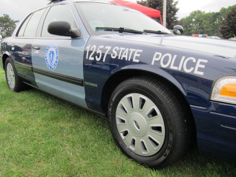 1991 Ford LTD Crown Victoria - Side view of a dark blue Massachusetts State Police Ford sedan marked '1257 STATE POLICE' with the state seal on the door.