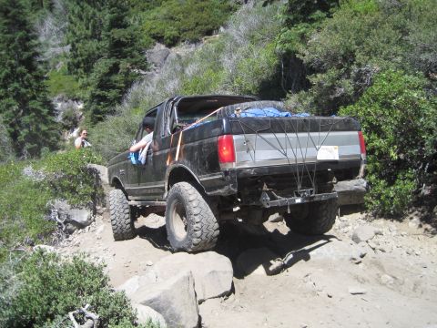 1989 Ford Bronco - This 1989 Ford Bronco navigates a challenging rocky trail in a wooded area.