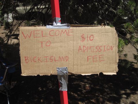 1989 Ford Bronco - A handmade sign indicates a $10 admission fee for Buck Island, attached to red posts with duct tape.