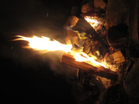 1989 Ford Bronco - A campfire burns brightly at night, with flames licking out from the logs.