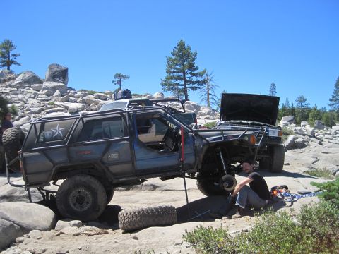 1989 Ford Bronco - Off-road vehicles undergoing maintenance on a rocky, sunny day.