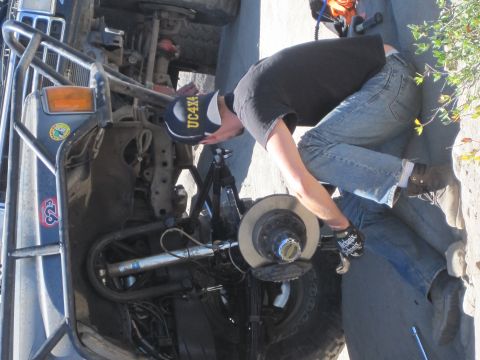 1989 Ford Bronco - A person is working on the brake system of a vehicle, possibly performing maintenance or repairs.