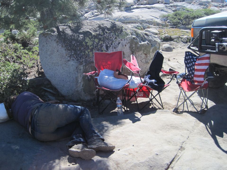 1989 Ford Bronco, front right quarter view, parked on rocky terrain with camping chairs nearby