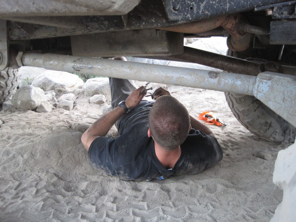 Person working on vehicle undercarriage