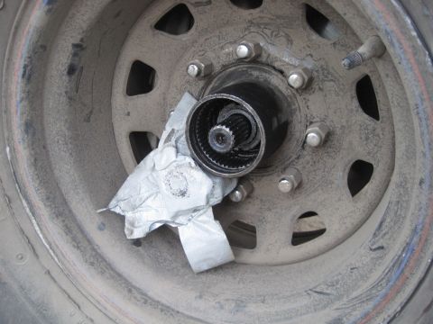 1989 Ford Bronco - Wheel hub assembly with visible splines and lug nuts, partially covered by tape.