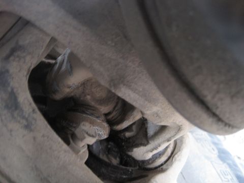 1989 Ford Bronco - This image shows a close-up view of a vehicle's suspension system, focusing on a greasy mechanical component.