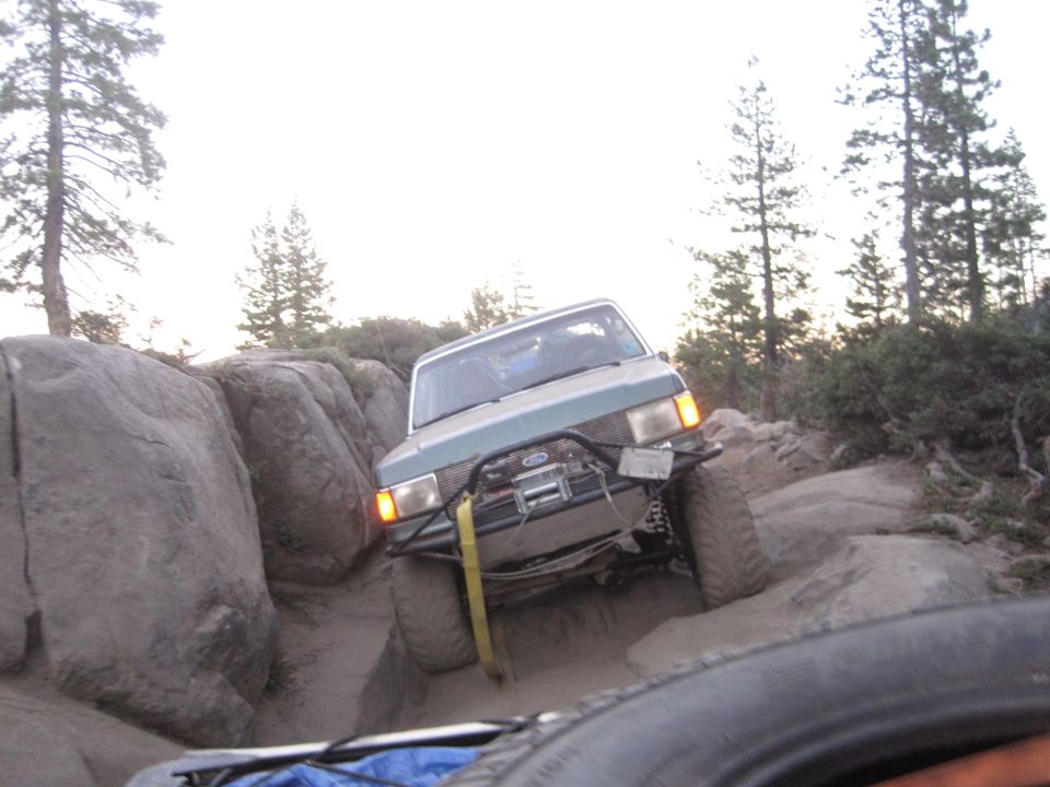 1989 Ford Bronco off-roading on a rocky trail, front winch visible