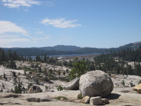 1989 Ford Bronco - A scenic view of a dam and lake surrounded by pine trees and rocky hills on a clear day.