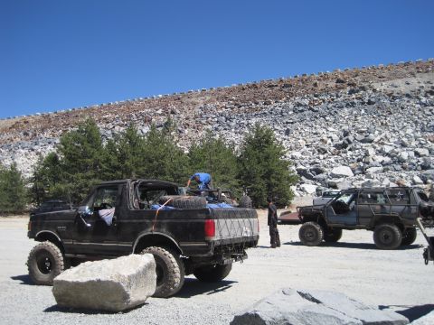1989 Ford Bronco - A modified 1989 Ford Bronco is parked off-road with another SUV in the background.