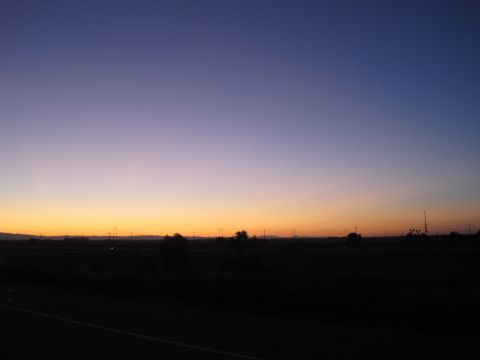 1989 Ford Bronco - The sky displays a beautiful gradient of purple and orange during sunset over a dark, rural landscape.