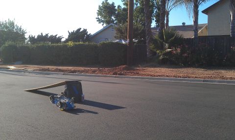 1992 Ford Ranger - A remote control car sits on the street next to a ramp and a bag.