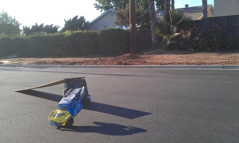 1992 Ford Ranger - A remote control car is positioned on a makeshift ramp on a suburban street.