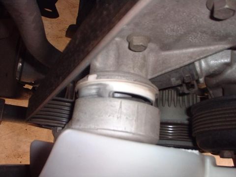 1996 Ford Taurus - A close-up view of the engine's belt tensioner and mount, showing mechanical components.