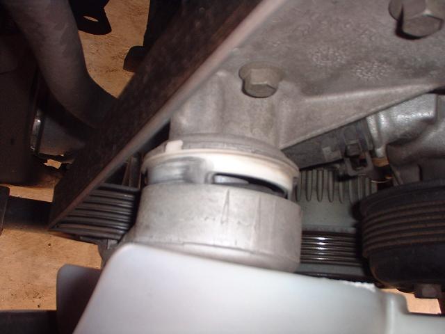 Close-up of a car's engine mount and belt tensioner assembly