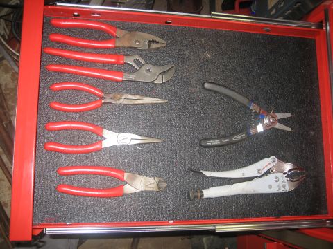 2010 Chevrolet Apache - A collection of pliers and other tools organized in a red tool drawer.