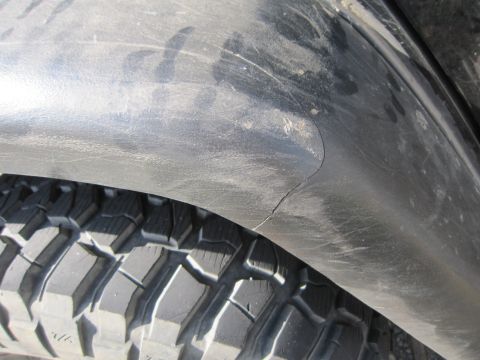 2008 Jeep Wrangler - Cracked fender flare on a vehicle, seen from the side near the tire.