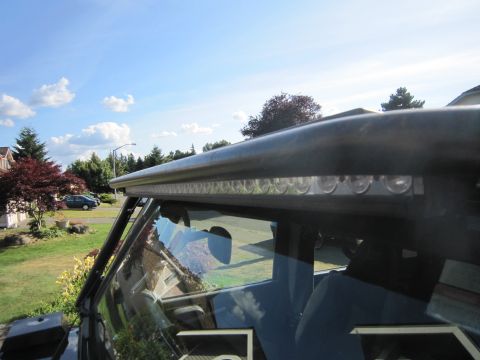 2008 Jeep Wrangler - An aftermarket LED light bar is installed on the roof of a vehicle, seen from inside the cabin.