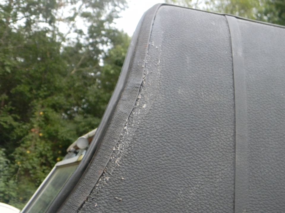 Close-up of the worn edge of a black vinyl vehicle top