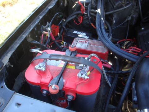 1989 Ford Bronco - Engine bay view showing a red Optima battery and an MSD ignition box, with various wires and cables.