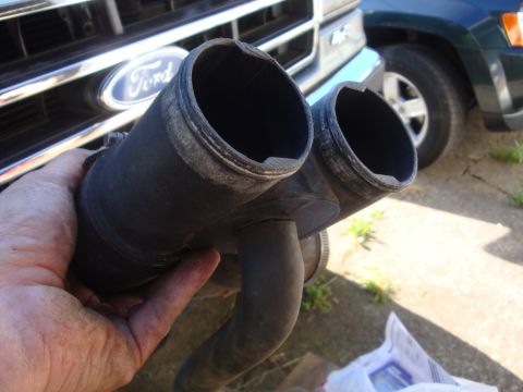 1989 Ford Bronco - Hand holds a dual-outlet engine coolant hose assembly with a Ford grille in the background.
