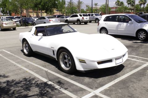 2006 Cadillac STS - A white C3 Corvette is parked in a lot, with other vehicles visible in the background.