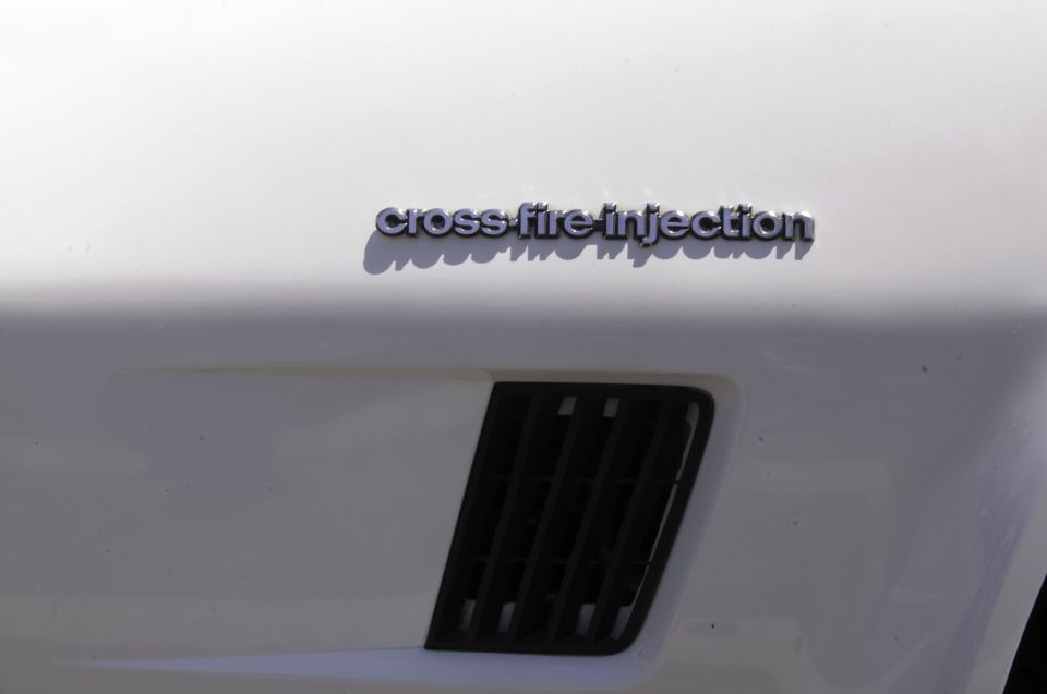 White car fender with "cross-fire injection" badge and black vent