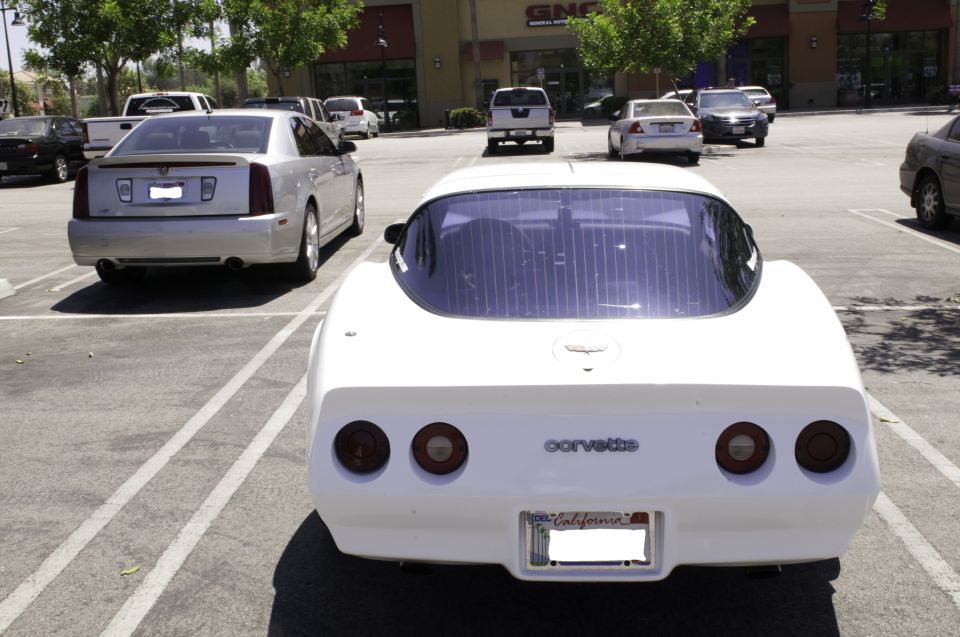 White Corvette rear view with California plates and 'Corvette' badging