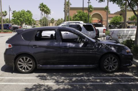 2006 Cadillac STS - A dark grey hatchback is parked in a lot with other vehicles and a trailer visible.