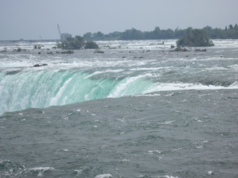 Niagara Falls with choppy water and a crane in the distance
