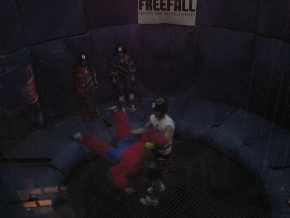 Indoor skydiving wind tunnel with people in flight suits