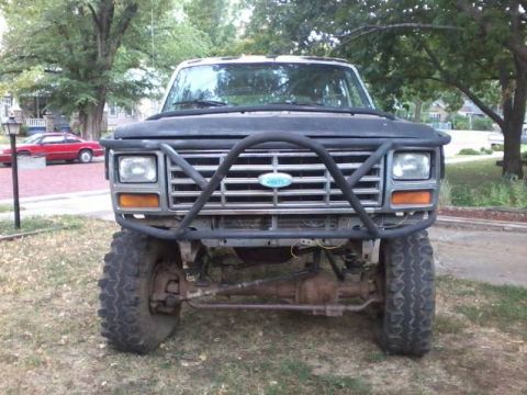 1986 Ford Bronco - This Ford Bronco features a prominent brush guard and appears to be lifted for off-road use.