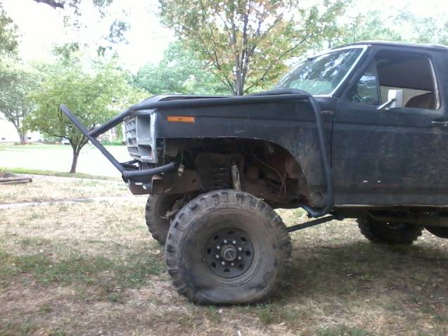Black off-road SUV with custom front bumper and large tires, showing front quarter view